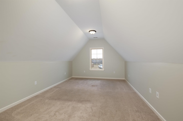 bonus room with light carpet and lofted ceiling