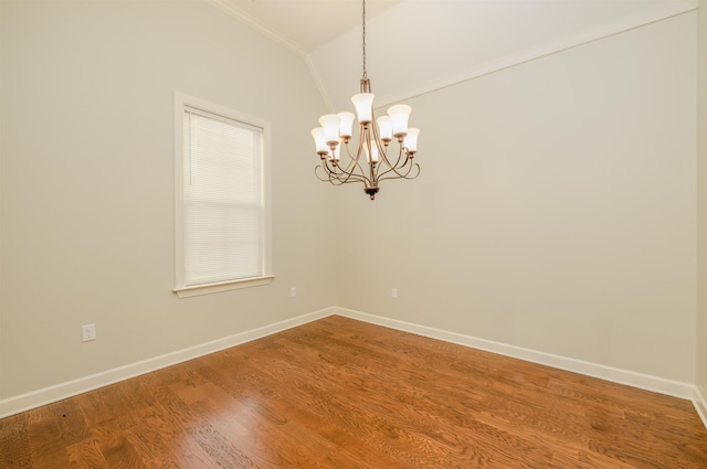 spare room featuring wood-type flooring, lofted ceiling, and a chandelier