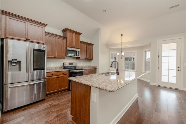 kitchen featuring sink, stainless steel appliances, an inviting chandelier, dark hardwood / wood-style floors, and an island with sink