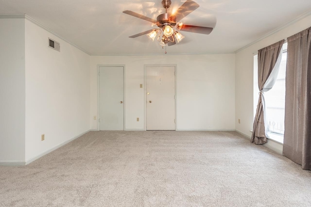 spare room with light carpet, plenty of natural light, ceiling fan, and crown molding