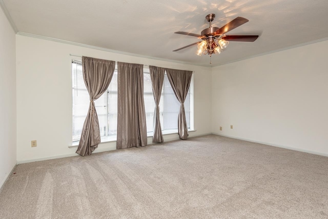 carpeted empty room featuring ceiling fan, plenty of natural light, and ornamental molding