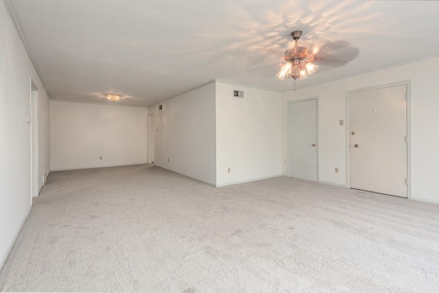 empty room with ceiling fan, light colored carpet, and crown molding