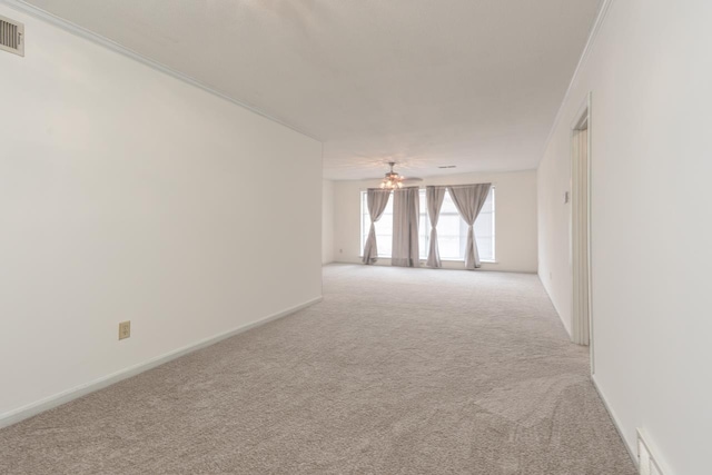 empty room with light colored carpet and crown molding