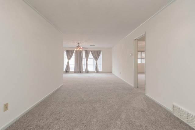 spare room featuring plenty of natural light, light colored carpet, and ornamental molding