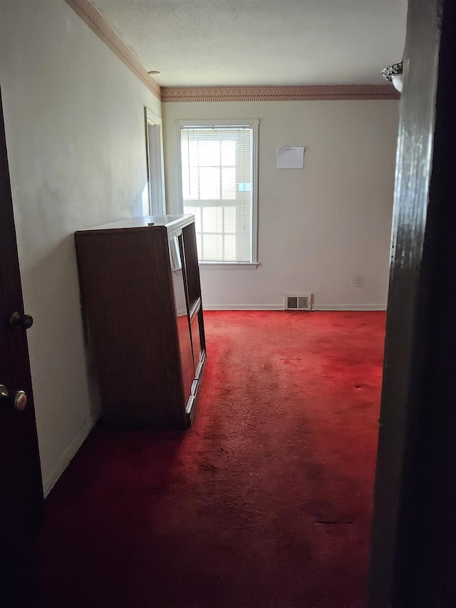 empty room with dark carpet and crown molding