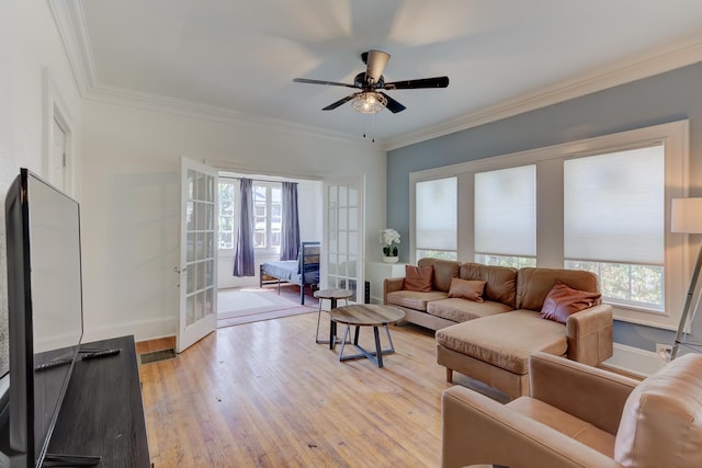 living room featuring french doors, light wood-type flooring, and ornamental molding