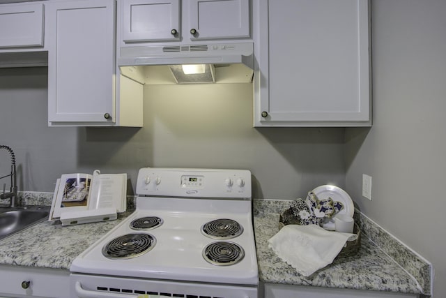 kitchen with white cabinets, white electric range, light stone counters, and sink