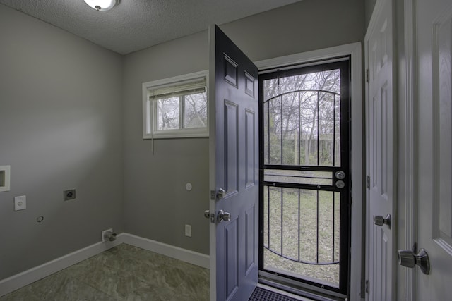 interior space with laundry area, baseboards, hookup for a gas dryer, a textured ceiling, and hookup for an electric dryer