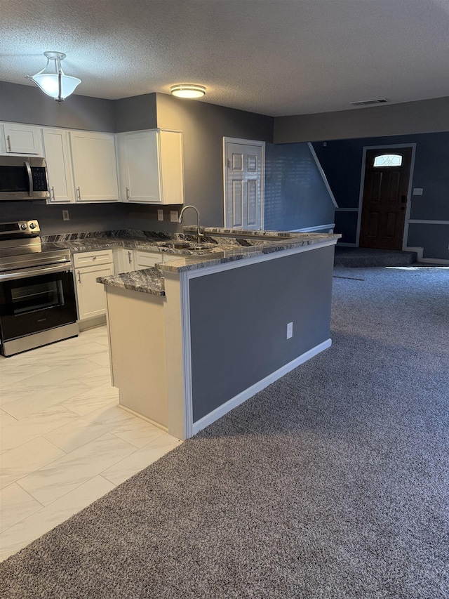 kitchen with white cabinetry, sink, kitchen peninsula, light carpet, and appliances with stainless steel finishes