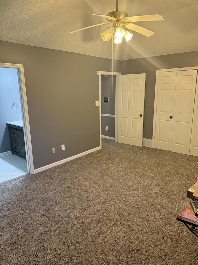 unfurnished bedroom featuring carpet flooring, ceiling fan, a closet, and a textured ceiling