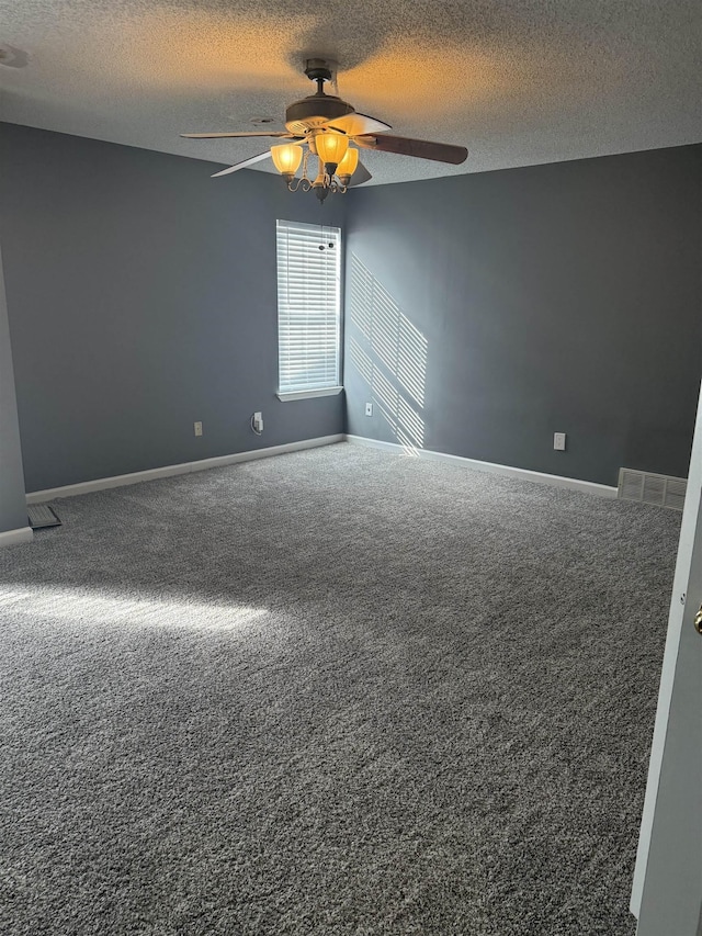 carpeted spare room featuring ceiling fan and a textured ceiling