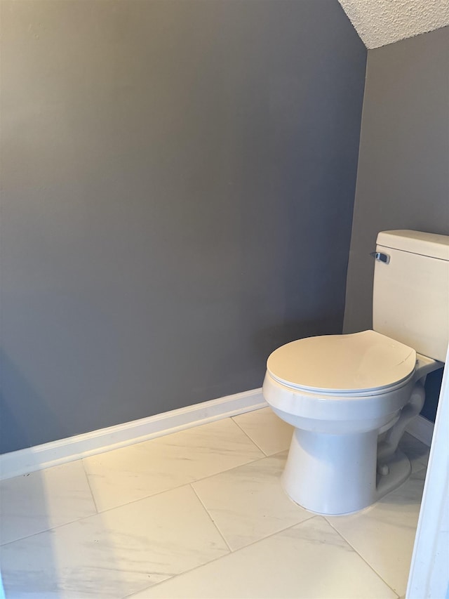 bathroom featuring tile patterned floors, toilet, and a textured ceiling