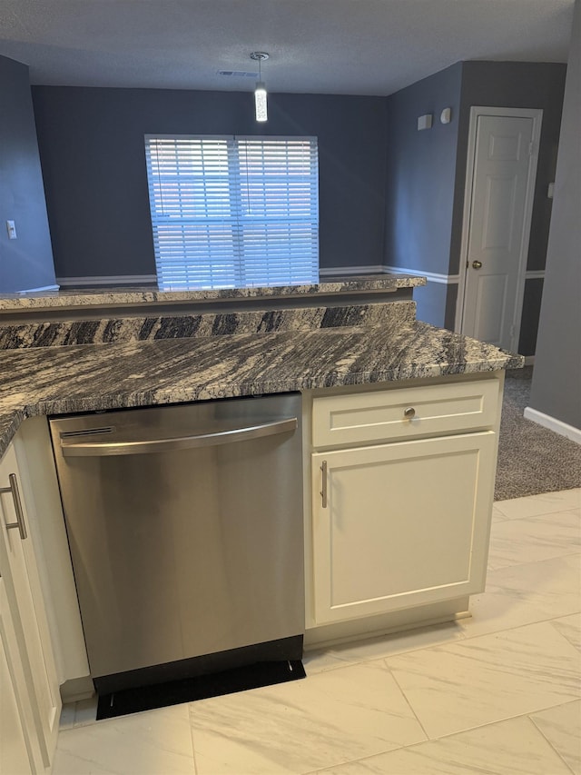 kitchen featuring dark stone countertops, dishwasher, and white cabinets