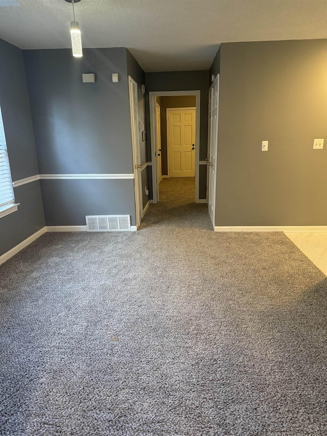 carpeted spare room featuring a textured ceiling