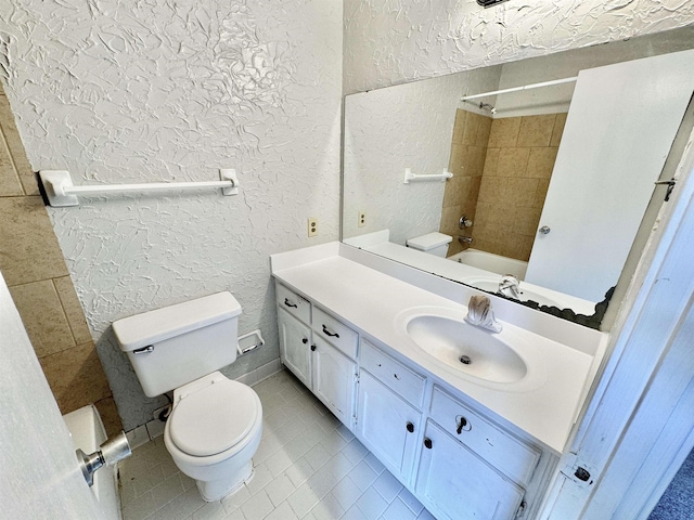 full bathroom featuring tile patterned flooring, vanity, toilet, and tiled shower / bath combo