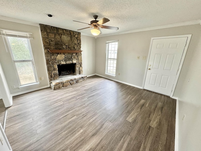 unfurnished living room featuring ceiling fan, wood-type flooring, ornamental molding, and a fireplace