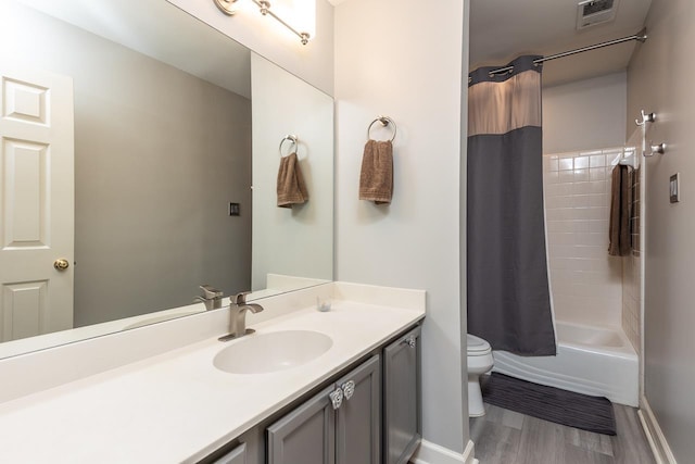 full bathroom with hardwood / wood-style floors, shower / bath combination with curtain, toilet, and vanity