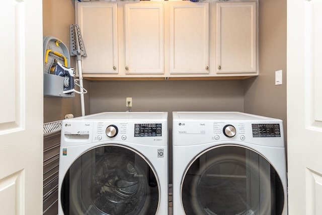 laundry area with separate washer and dryer and cabinets