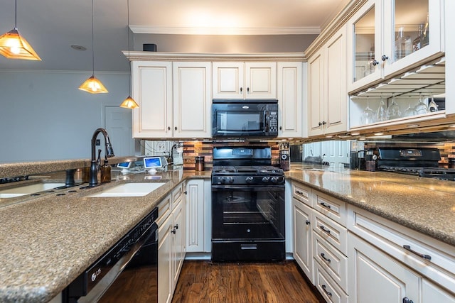 kitchen featuring light stone countertops, crown molding, black appliances, and decorative light fixtures