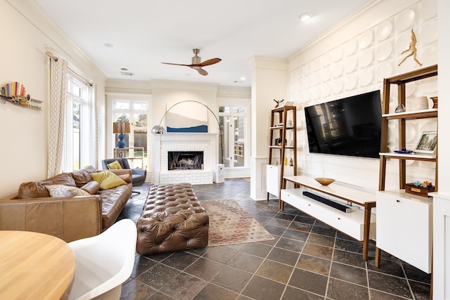 living room with ceiling fan, a fireplace, and ornamental molding