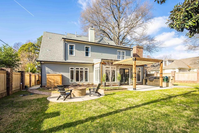 rear view of house featuring a pergola, a yard, area for grilling, a patio area, and an outdoor fire pit