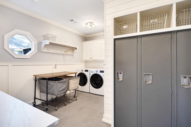 clothes washing area featuring light tile patterned flooring, cabinets, independent washer and dryer, and ornamental molding