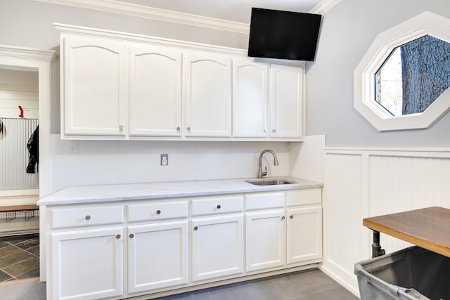 kitchen with sink, white cabinets, and ornamental molding