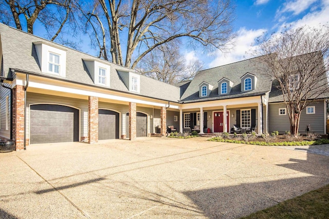 cape cod house featuring covered porch and a garage