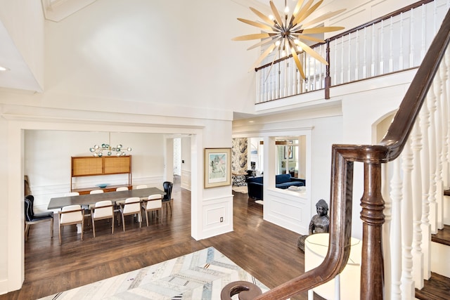 interior space featuring dark hardwood / wood-style flooring, a high ceiling, and a notable chandelier