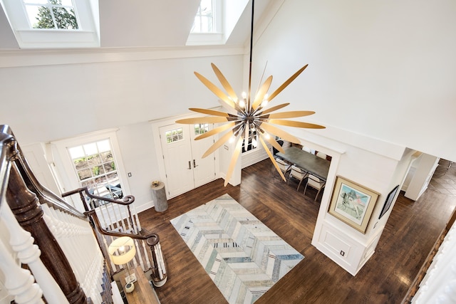 living room with dark wood-type flooring, high vaulted ceiling, and an inviting chandelier