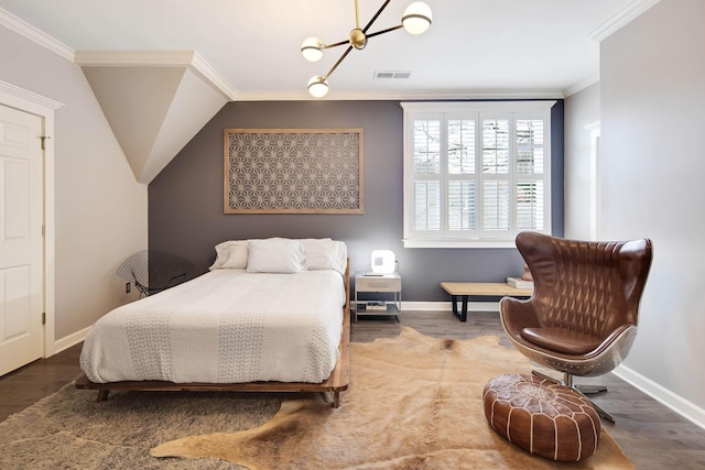 bedroom featuring a notable chandelier, ornamental molding, and dark wood-type flooring