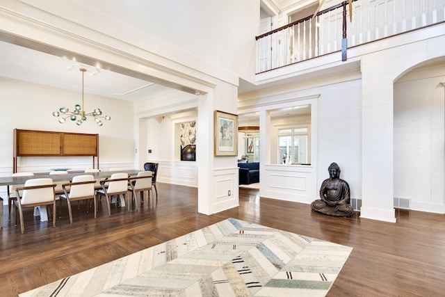 dining room featuring a chandelier, dark hardwood / wood-style flooring, a fireplace, and ornamental molding