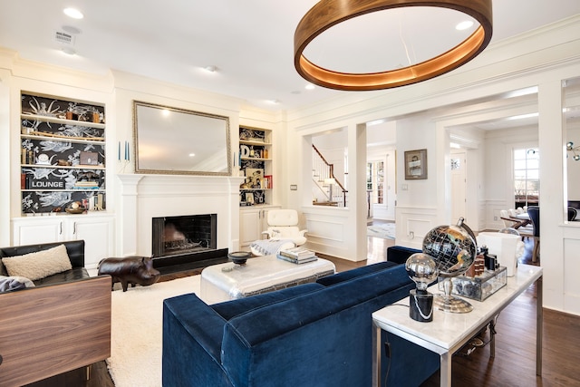 living room featuring built in features and dark wood-type flooring