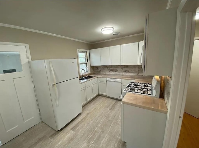 kitchen featuring sink, tasteful backsplash, crown molding, white appliances, and white cabinets