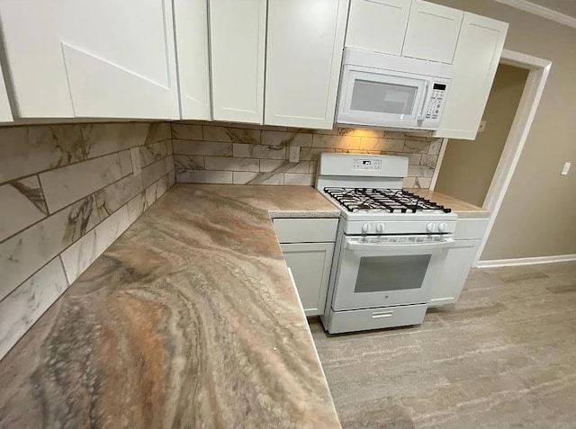 kitchen with white appliances, tasteful backsplash, white cabinetry, and ornamental molding