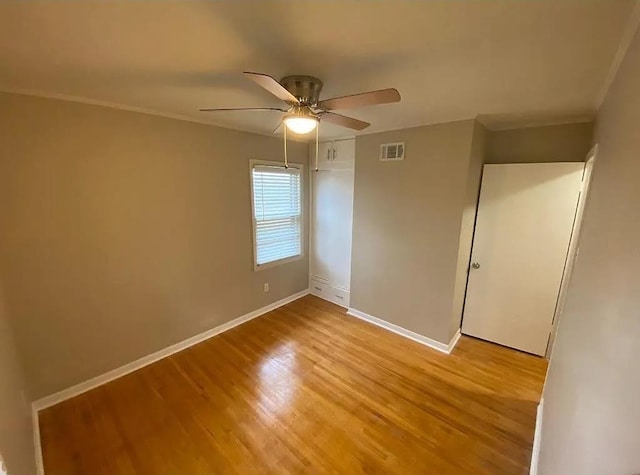 empty room with ceiling fan and light hardwood / wood-style flooring