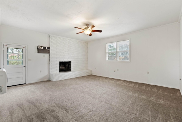 unfurnished living room featuring carpet flooring, a brick fireplace, and a wealth of natural light