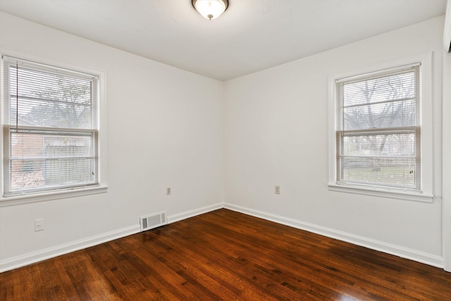 unfurnished room with plenty of natural light and dark hardwood / wood-style floors