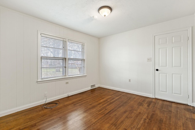 empty room with dark hardwood / wood-style flooring