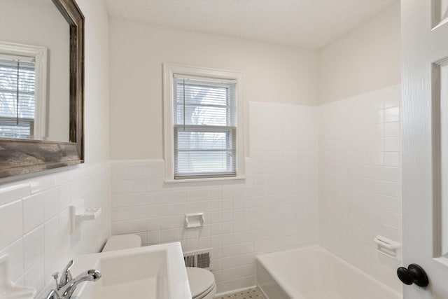 bathroom with tile patterned flooring, toilet, and tile walls