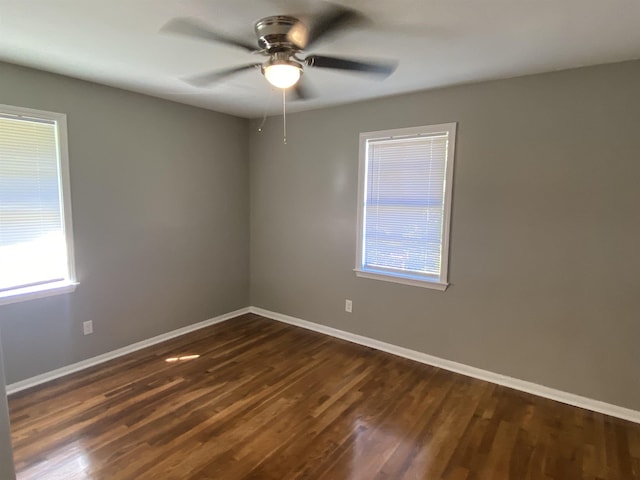 empty room with ceiling fan and dark hardwood / wood-style flooring