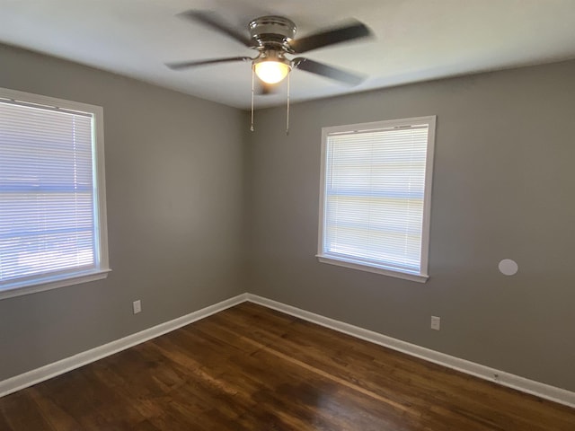 spare room with dark hardwood / wood-style floors and ceiling fan