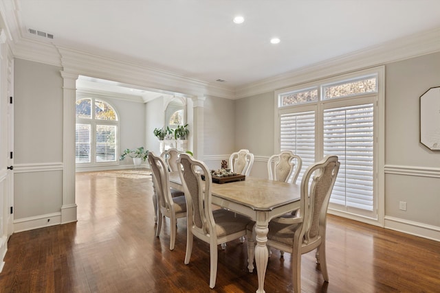 dining room featuring decorative columns, dark hardwood / wood-style floors, and ornamental molding