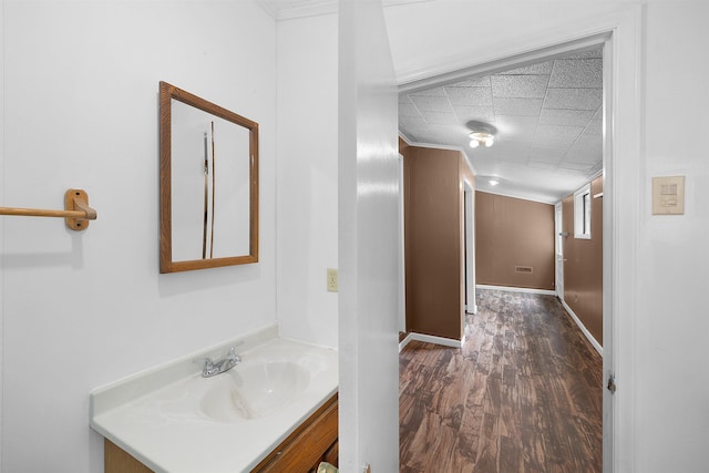 bathroom with crown molding, hardwood / wood-style floors, and vanity