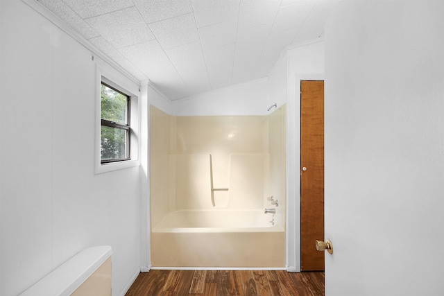 bathroom with hardwood / wood-style floors, shower / bath combination, and vaulted ceiling