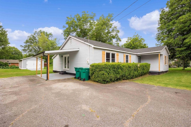 view of front of property with a shed, a front yard, and a carport