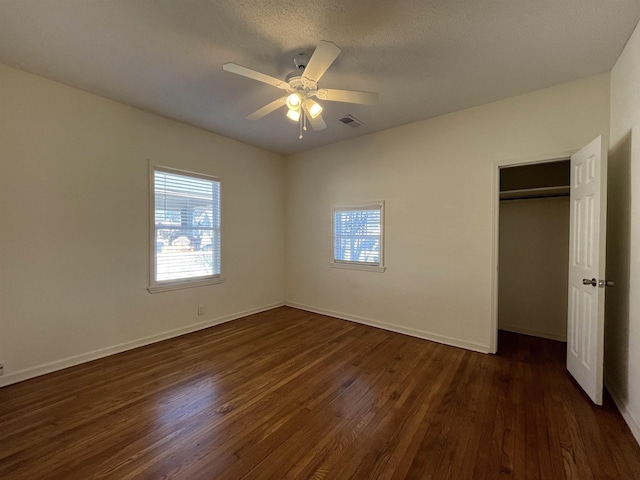 unfurnished bedroom featuring a closet, ceiling fan, dark hardwood / wood-style flooring, and a textured ceiling