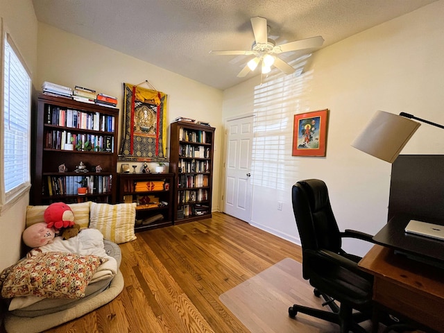 office space with a textured ceiling, hardwood / wood-style flooring, and ceiling fan