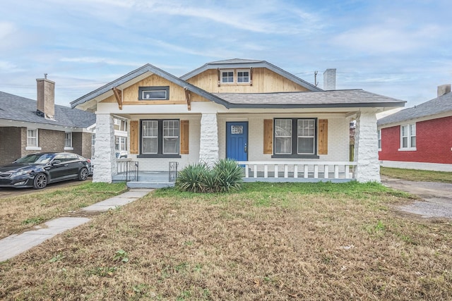 view of front of property with covered porch and a front yard