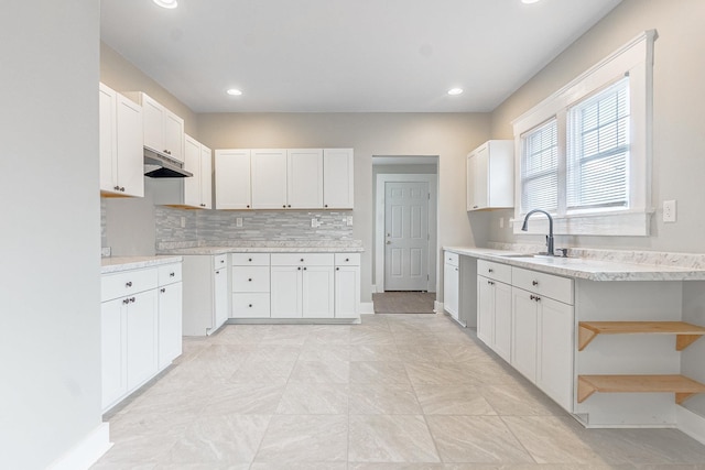 kitchen featuring tasteful backsplash, dishwasher, sink, and white cabinets